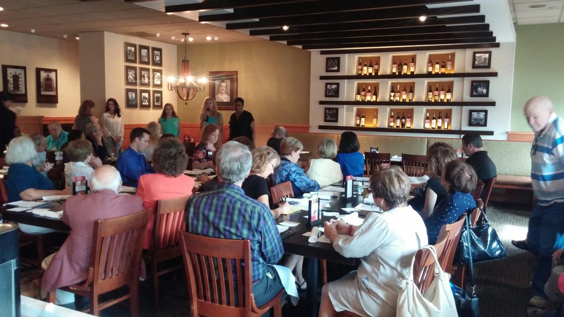 A group of people sitting at tables eating food.