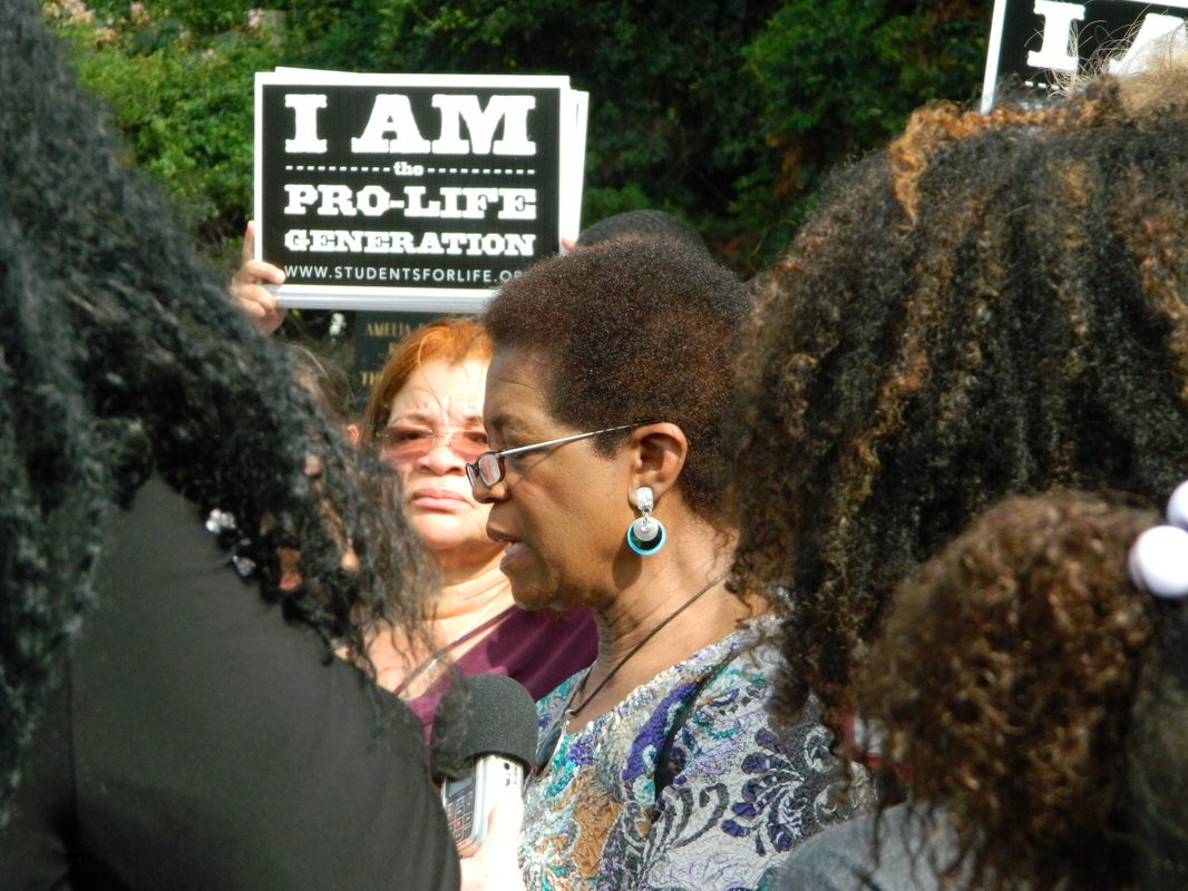 A group of people gathered around a sign.