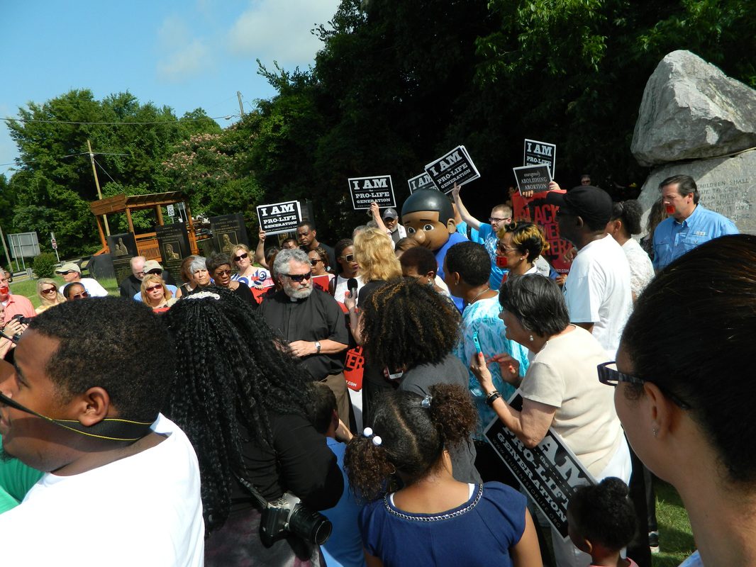 A crowd of people standing around each other holding signs.