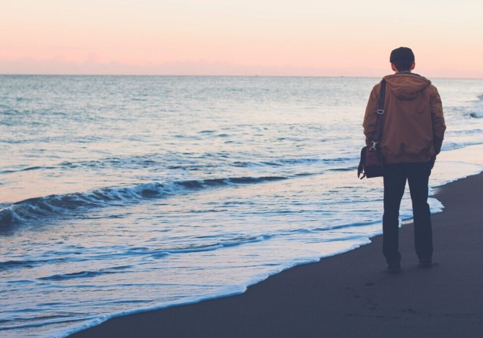 A person walking on the beach with their bag