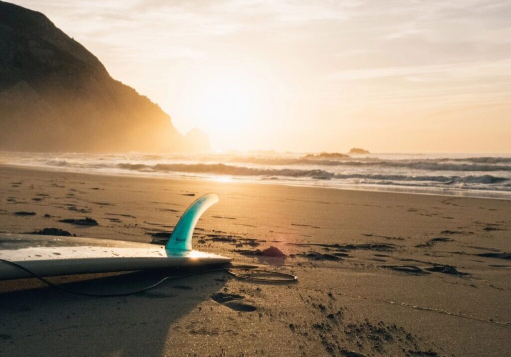 A surfboard sitting on top of the beach.